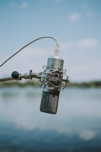Ein Mikrofon vor einem See, symbolisierend für Interviews, die Johannes Becht durchgeführt hat